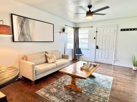 Modern Bricktown Studio — Bright, open living space with sleek ceiling fan, cozy sofa, and natural light from large windows.







