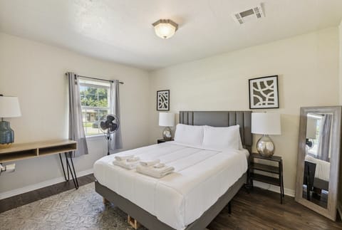 Bedroom 1 — queen bed, blackout curtains, full-length mirror