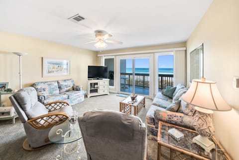 Relax in your spacious oceanfront living room where soft coastal furnishings and panoramic sea views create the perfect beach getaway retreat.