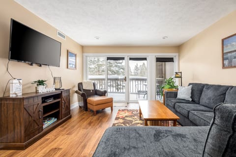 Relax in the cozy living room w/ warm wood floors, comfy seating & glass doors leading to a private patio.