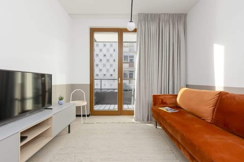 Living room with TV with cable channels and Smart TV function, sofa bed and exit to balcony.