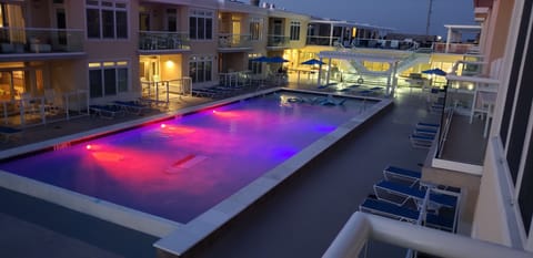 Balcony view of the fun, outdoor, pool at night.