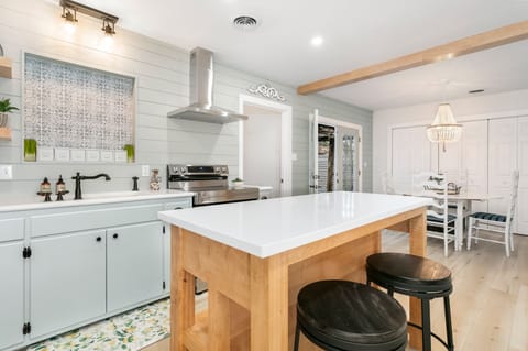 Gather around the cozy wooden island in the kitchen for a fun cooking session with friends.