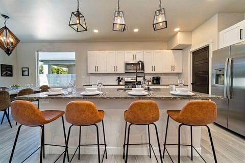 Kitchen that’s both chic and functional, with luxe granite countertops, pendant lighting, and velvet bar stools inviting you to dine in style