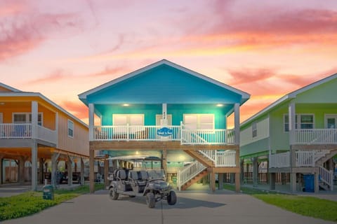 Beautiful beach house with golf cart included, glowing under a coastal sunset.