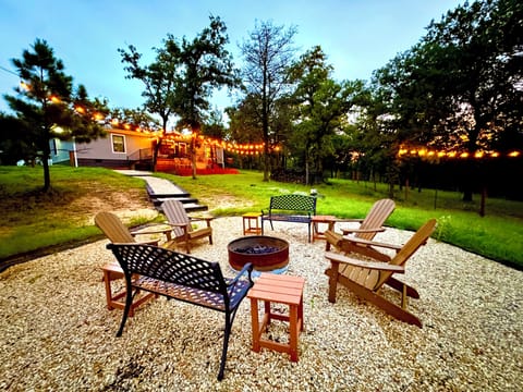 Fire pit with benches and adirondack chairs. Stocked with firewood.