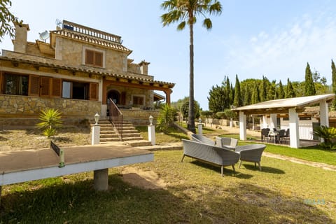 Exterior view of Villa Alejandra with private garden, outdoor seating areas and Mediterranean surroundings, perfect for relaxing in Mallorca.