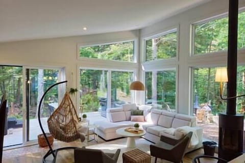 Le salon convivial et chaleureux avec son foyer au bois et sa chaise oeuf hyper confortable