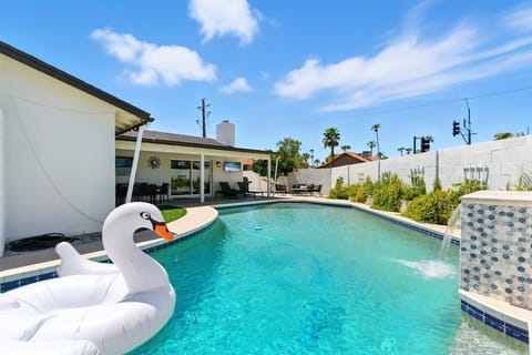 Private yard with sparkling pool, sun loungers, cornhole, and outdoor covered patio with BBQ grill.