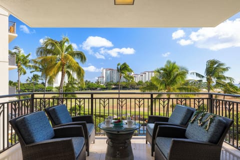 Unwind on your private balcony with plush seating overlooking tropical palms and resort grounds—perfect for morning coffee or sunset relaxation.