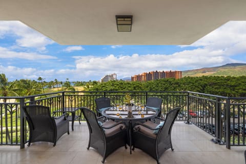 Savor your morning coffee on this covered lanai with sweeping views of lush landscapes and distant resort towers.