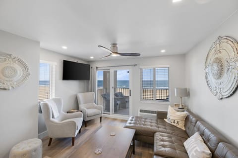 Oceanfront comfort meets boardwalk views 🌊 Relax in this bright living room with cozy seating, smart TV, and balcony access for sunrise coffee and salty breezes, just steps from the sand in Virginia Beach! ☀️🏖️