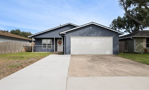 The home appears to be a single-story ranch style with a stucco exterior and a clay tile roof. The front yard is landscaped with mature trees and shrubs, and there is a covered patio in the back. The driveway is paved and well maintained