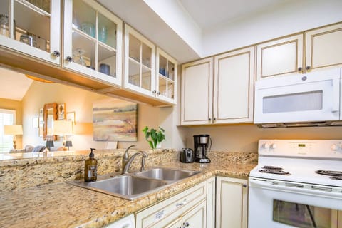 The kitchen features white cabinetry and granite countertops.