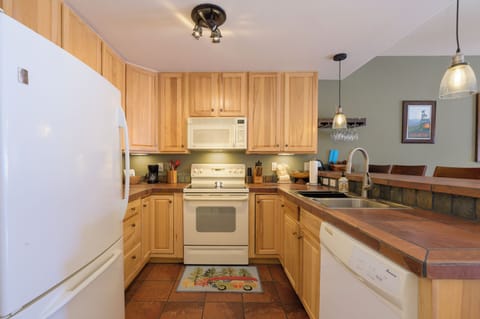 Your fully-equipped kitchen awaits with warm wood cabinets, modern appliances, and everything you need to create memorable meals during your stay.