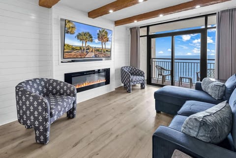 Enjoy the living room space with wooden beams, Alexa-controlled motorized blinds, an electric fireplace, and a 70" LG Smart TV.