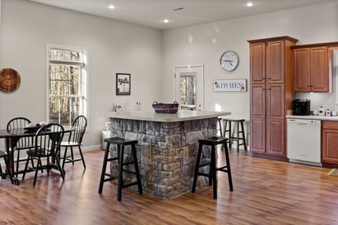 Elegant kitchen featuring a stone island bar and ample seating, perfect for morning coffee 
