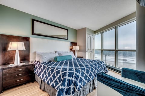 A luxurious bedroom with a king-sized bed, floor-to-ceiling windows