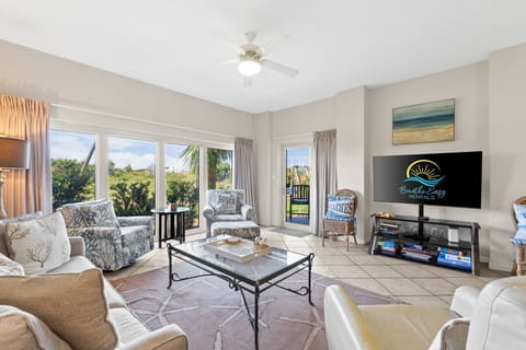 Open and airy living room with ample seating, a large flat-screen TV, and stunning views all around.