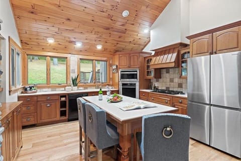 This bright and airy kitchen, adorned with natural wood finishes and modern appliances, offers a picturesque view of the surrounding greenery, inviting you to dine in the heart of nature.