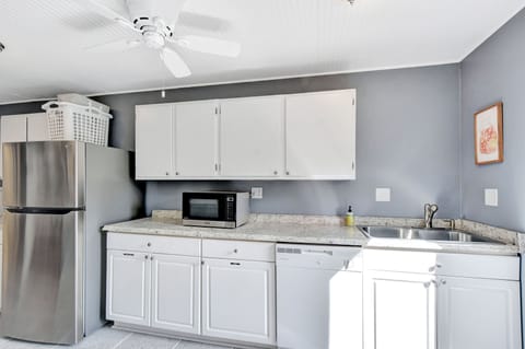 Second Kitchen with Extra Fridge and Microwave – Beach Crew Cott - This bonus kitchen features additional counter space, a stainless fridge, microwave, and extra cabinets for overflow snacks, coffee gear, or party prep. It’s a quiet backup that makes a big difference for groups.