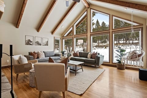Primary living room on the main floor with cozy seating options, a wood-burning fireplace, and a sofa bed for additional sleeping space (bedding provided.).