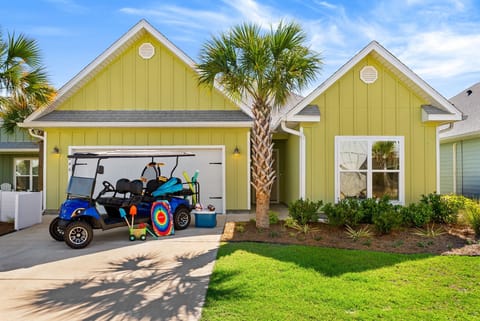 Cheerful home with garage, palm trees, and landscaped lawn, located in a welcoming coastal neighborhood perfect for family getaways.