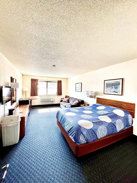 Cozy room with one queen bed, pull out sleep sofa, a mini fridge, and single-serve coffee maker—perfect for a comfortable Northwoods stay.