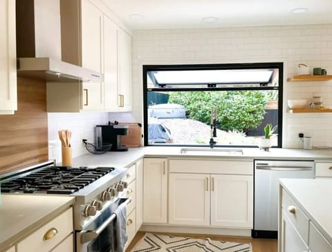 Open kitchen with indoor/outdoor pass-through window to BBQ and small bar.