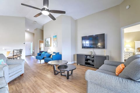 Bright, open living area with vaulted ceilings, comfortable seating, and a 65` Smart TV — perfect for relaxing after a day at the parks