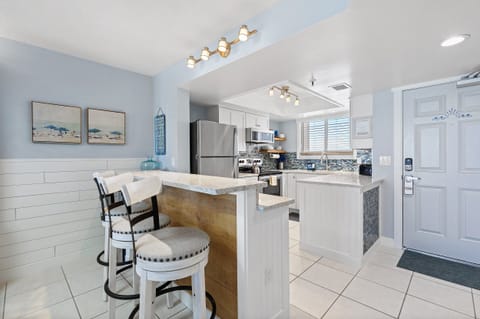 A beautifully lit kitchen with a stylish breakfast bar and coastal decor perfect for casual dining.