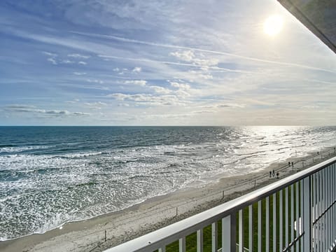 Breathtaking view of the sun rising over the ocean, casting golden light on the waves.