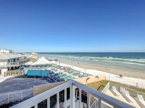 Relax by the shore with stunning ocean views, turquoise lounge chairs, and the calming sound of waves in this perfect beachfront retreat.