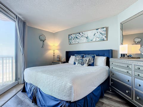 King-sized bed with marine-inspired decor and soft tones, creating a serene retreat by the sea.