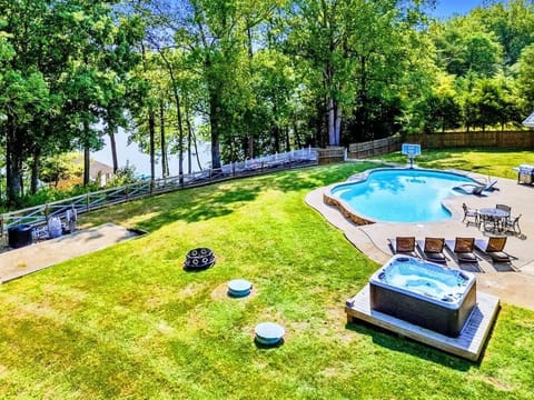 Relax in your shaded and fenced backyard oasis featuring a pool, hot tub, fire pit, floaties, and a hammock for the ultimate outdoor retreat.