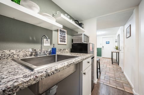 Compact yet efficient, the kitchenette offers everything you need for light meals—featuring a granite countertop, microwave, mini fridge, Keurig coffee maker, and open shelving stocked with essentials.







