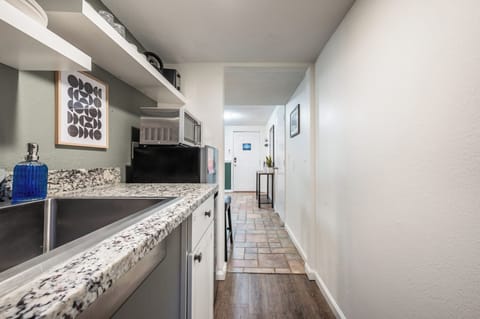 Compact yet efficient, the kitchenette offers everything you need for light meals—featuring a granite countertop, microwave, mini fridge, Keurig coffee maker, and open shelving stocked with essentials.







