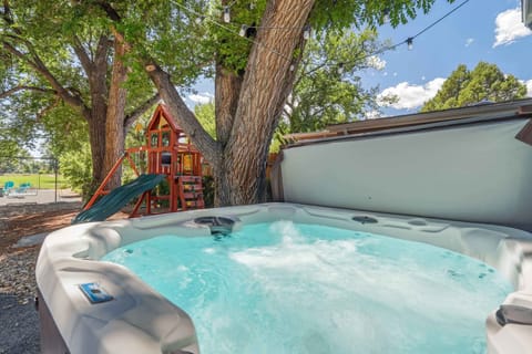 Welcome to Mulligan Magic! Experience the ultimate backyard retreat with comfortable seating, a delightful playground, exciting cornhole, and a warm fire pit, offering something for everyone to enjoy in this outdoor haven.