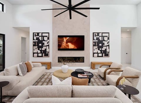 Grand open-concept living space with designer decor, featuring a fireplace and Smart TV.