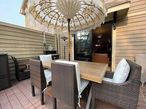 Inviting outdoor deck with comfortable dining seating and a large umbrella 