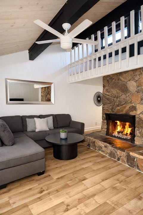 Cozy mountain living room featuring a spacious sectional sofa and a warm gas fireplace — the perfect place to relax after a day on the slopes.