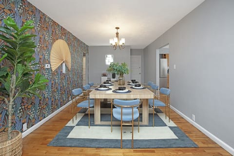 Minimalist dining with blue chairs and wood table.