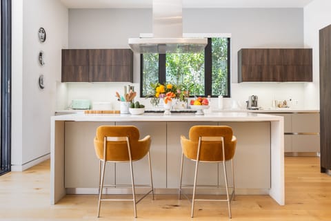 Modern kitchen features an island with barstool seats.