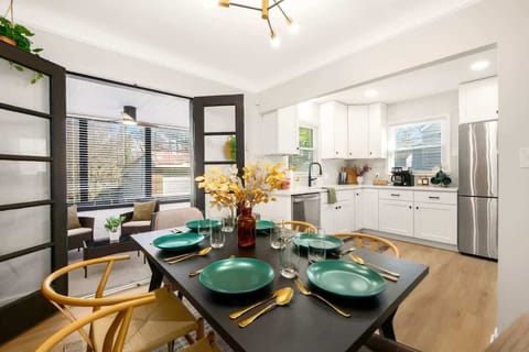 Elegant dining table set for meals, framed by glass doors & soft natural light