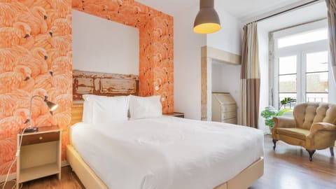 Relax in this room with a comfortable queen-sized bed, and adorned with vibrant wallpaper and classic repurposed furniture. #decoration #lisboa #vacations #airbnb