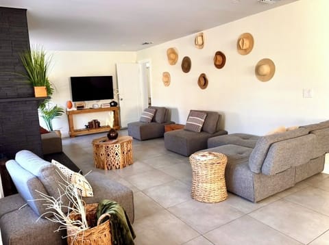 Living room, 50" smart tv, wood burning fireplace, access to bathroom, backyard and open concept living/dining room