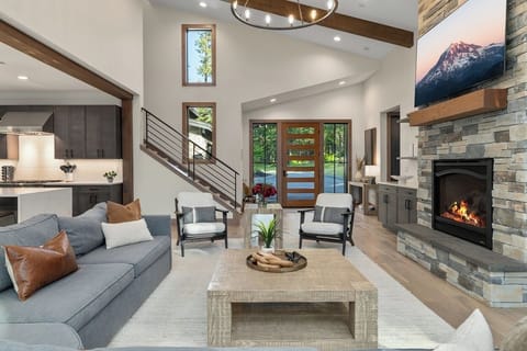 Great Room – Soaring Ceilings, Stone Fireplace, Designer Furnishings, and Open-Concept Layout.