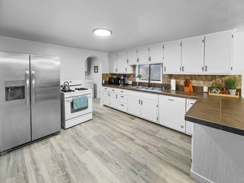 Fully furnished kitchen with oven, microwave, refrigerator, and dishwasher