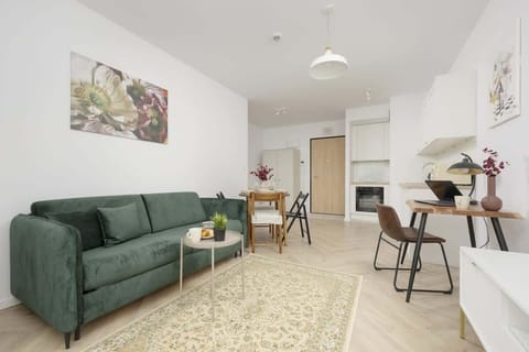 A stylish living room with a green velvet sofa, a modern coffee table, and a cozy rug, creating a sophisticated yet inviting ambiance.

