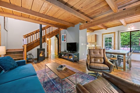 The comfy living room with gas stove and entertainment open to the dining area.